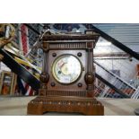 Wooden cased brass clock with ornate carved top and key