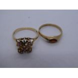 Two 9ct yellow gold dress rings, one set with pale rubies and the other set with a garnet, both mark