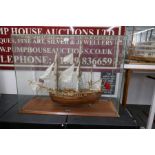 A kit built model of HMS Endeavour in glass case, with mahogany base, 96cm