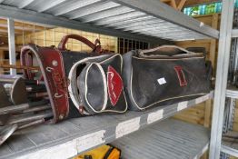Two golf bags with golf clubs and a wooden bottle rack