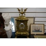An ornate French style brass mantel clock on lion paw feet, height 57cms