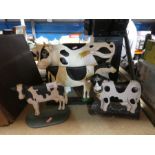 A selection of metal door stops depicting cows, plus another