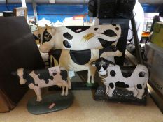 A selection of metal door stops depicting cows, plus another