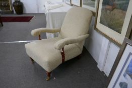 A Victorian style fireside armchair, having open arms by Laura Ashley