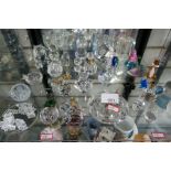 A shelf of glass animals, trinkets, glass clock, paperweights, some being Swarovski