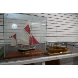 A wooden fishing boat in glazed case and one other of Thames Steam Cruiser, the largest 68.5cm