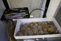 A quantity of pens including some fountain examples and a small quantity of mixed coins