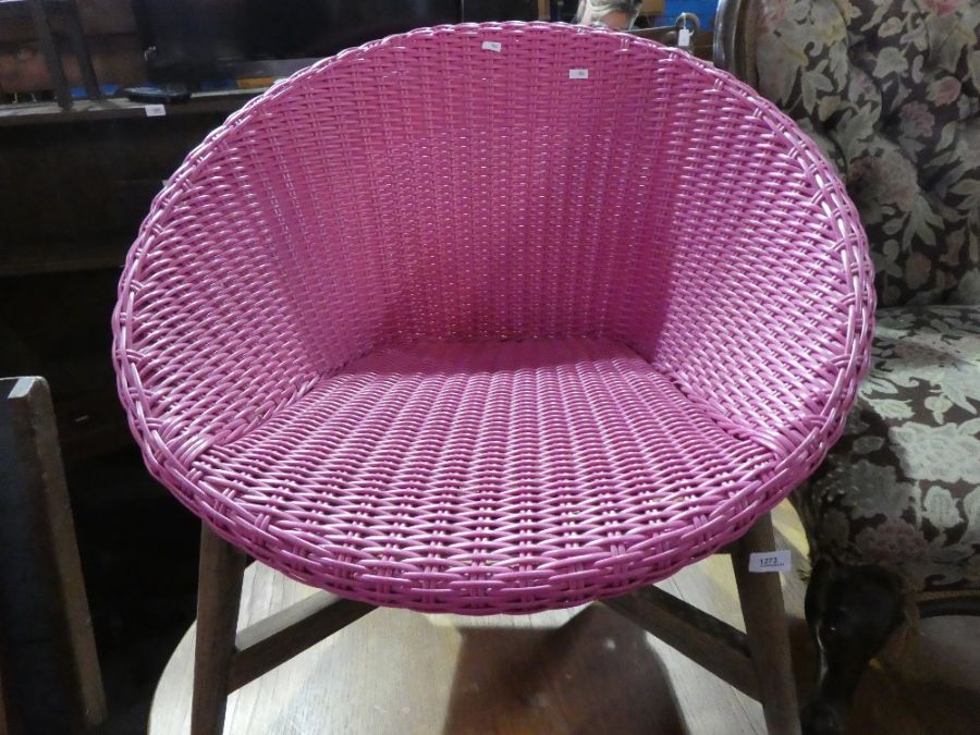 Retro pink woven tub chair of large proportions on wooden supports