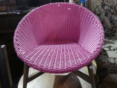 Retro pink woven tub chair of large proportions on wooden supports