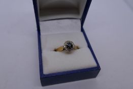 18ct yellow gold cluster ring with raised central sapphire surrounded diamond chips, 3.8g approx