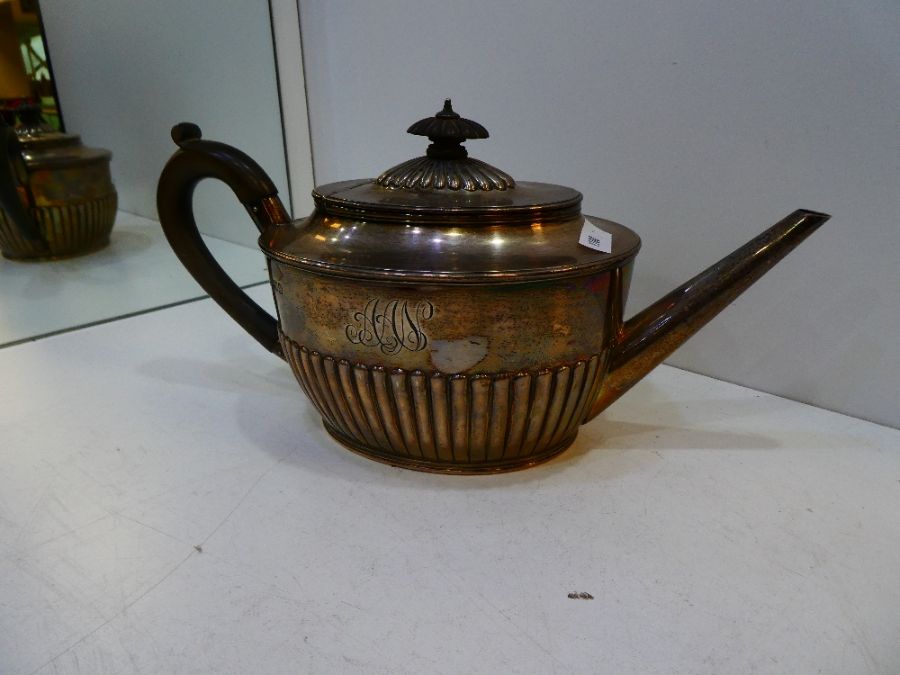 An Edwardian silver teapot with gadrooned body and central engraved initials AA. Hallmarked London 1
