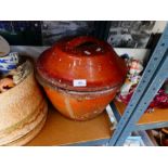 A shelf of various collectables, including brass, ceramics and an earthenware pot