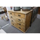 An antique stripped pine chest of drawers on bun feet, 102cm