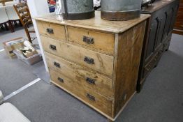 An antique stripped pine chest of drawers on bun feet, 102cm