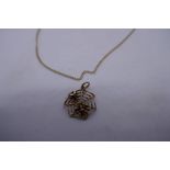 9ct yellow gold necklace hung with a spider web pendant and a 9ct yellow gold cobweb charm, also mar