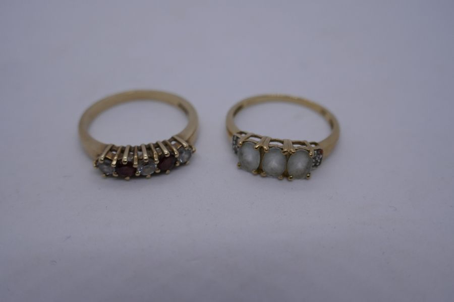 2 9ct yellow gold dress rings, one set with garnets and clear stones the other 2 oval white stones,