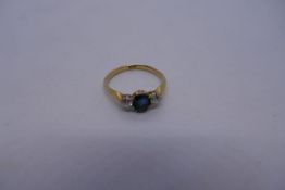18ct yellow gold trilogy ring set with central sapphire stone flanked two 0.10 diamonds, marked 18