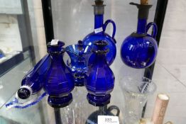 Two old Bristol blue glass decanters, a pair of blue glass bottles with stoppers and other items