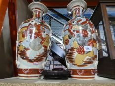 A pair of oriental Satsuma vases with holes in the bottom on bases