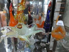Two shelves of coloured glass to include 1 Murano style clown, birds, fish, bowls, paperweights and