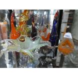 Two shelves of coloured glass to include 1 Murano style clown, birds, fish, bowls, paperweights and