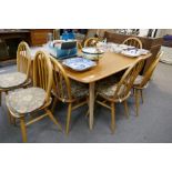 An Ercol Elm oblong dining table and a set of 8 Ercol stickback chairs
