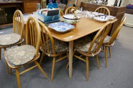 An Ercol Elm oblong dining table and a set of 8 Ercol stickback chairs