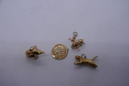 4 9ct yellow gold charms, to incl. an elephant, ballerina, tiger and a medallion AF, all marked 375,