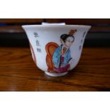 A Chinese tea cup decorated figures and words