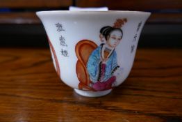 A Chinese tea cup decorated figures and words