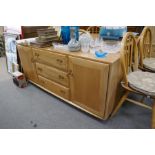 An Ercol Elm sideboard having 3 central drawers flanked by cupboards 155cm