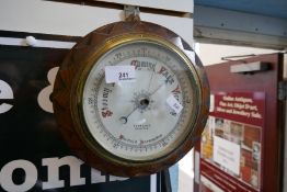 A small carved oak aneroid barometer