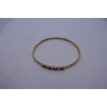 9ct yellow gold bangle set with cubic zirconia and sapphire, marks worn, approx 6cm diam, 6g
