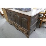 An antique oak mule chest having panelled front with 3 drawers 152cm