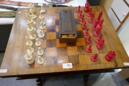 19th Century carved ivory chess set and draughts set on a mahogany chess table