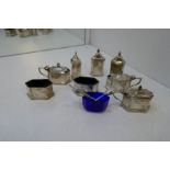 A selection of silver salts, peppers and salt spoons with Bristol blue inserts. With one plate small