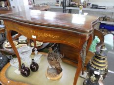 A reproduction French inlaid foldover card table having metal mounts on cabriole legs