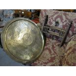 An Eastern brass tray top table on folding base