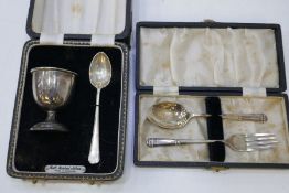 A cased silver egg cup and spoon and with a silver cased spoon and fork. 2.48 ozt approx