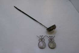 A white metal ladle with a twisted bone handle AF with two 1769 coins on stands