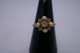 9ct yellow gold dress ring in the form of a flower with central diamond surrounded seed pearls and d