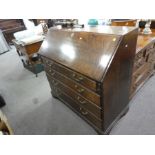 An antique oak bureau having 4 long graduated drawers on bracket feet, 106cm
