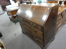 An antique oak bureau having 4 long graduated drawers on bracket feet, 106cm