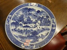 An oriental blue and white charger, probably Japanese, decorated figures in landscape, 35.5cms