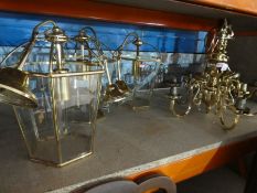 Three modern hexagonal glass lanterns and a pair of five branch chandeliers