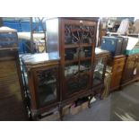 An antique mahogany sideboard having scroll decoration and three glazed doors