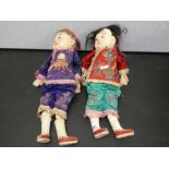 A pair of Chinese Papier Mache dolls having embroidered outfits