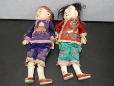 A pair of Chinese Papier Mache dolls having embroidered outfits