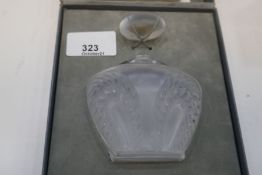 A Lalique Singapore perfume bottle and one other decorated faces with partial contents, both boxed