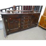 An 18th century oak dresser base having 4 central drawers flanked by cupboards, 181cm